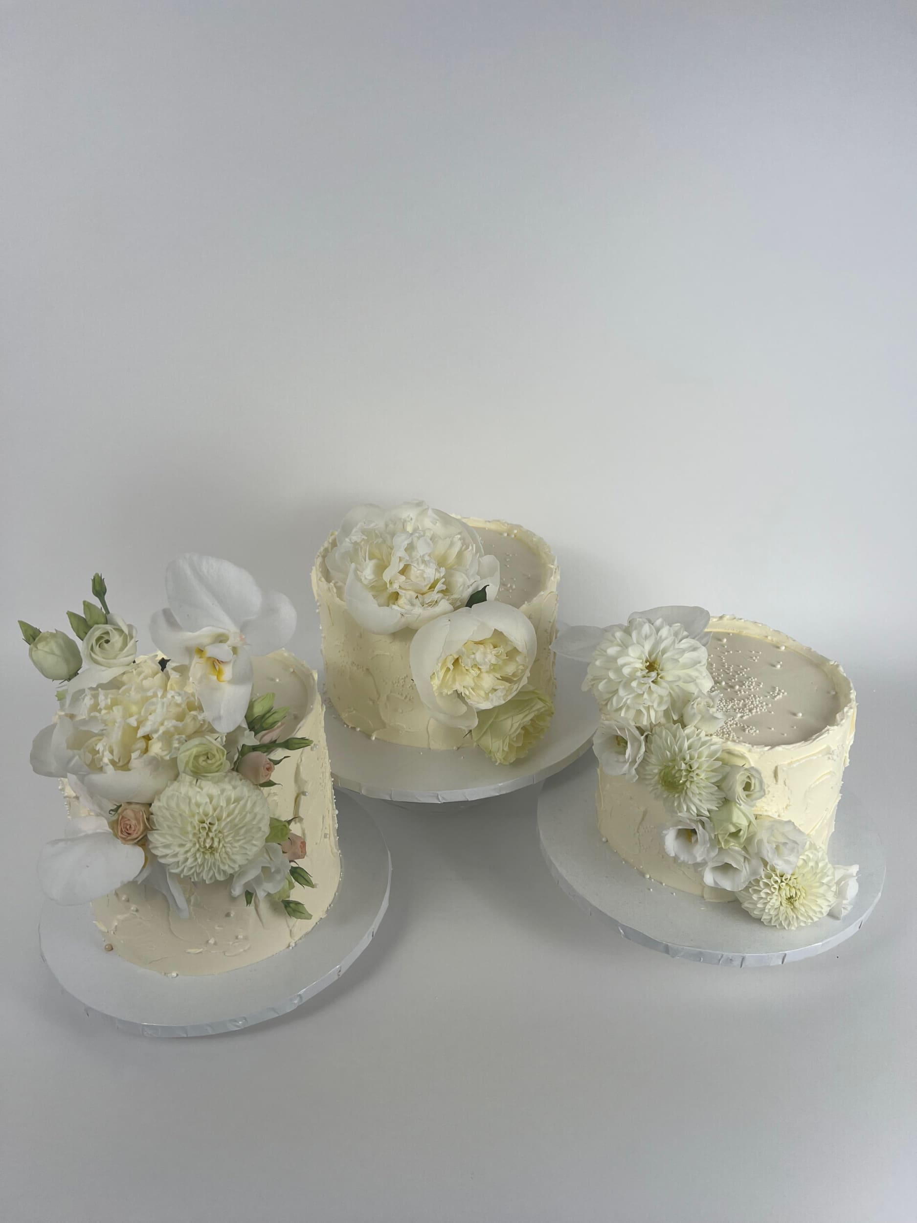 Cascading fresh blooms on buttercream - wedding cake