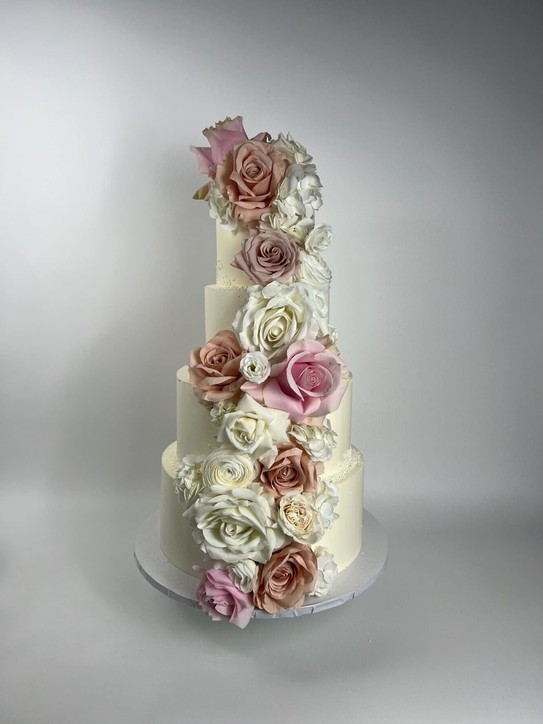 Cascading fresh flowers on buttercream - wedding cake