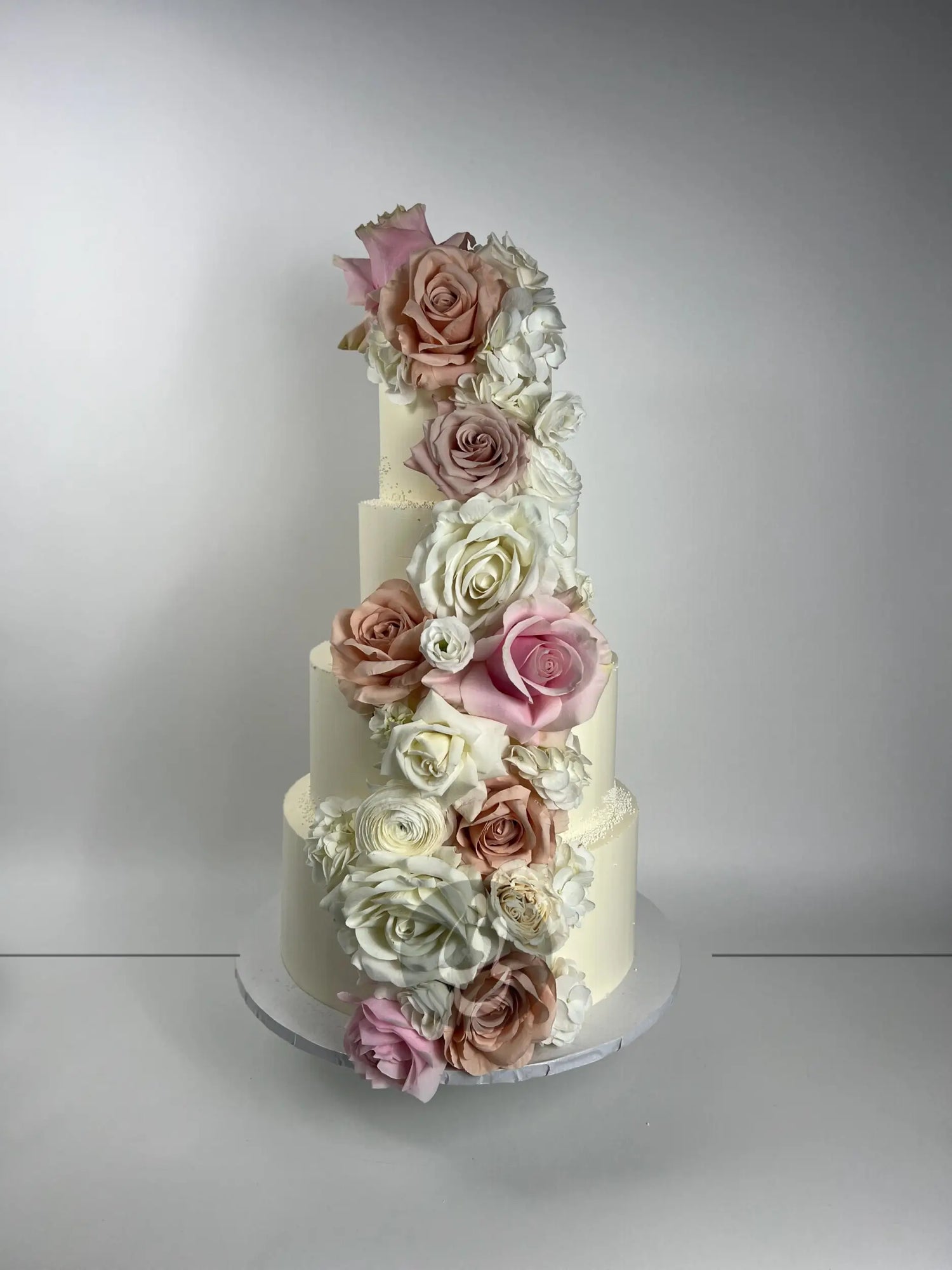Cascading fresh flowers on buttercream - wedding cake