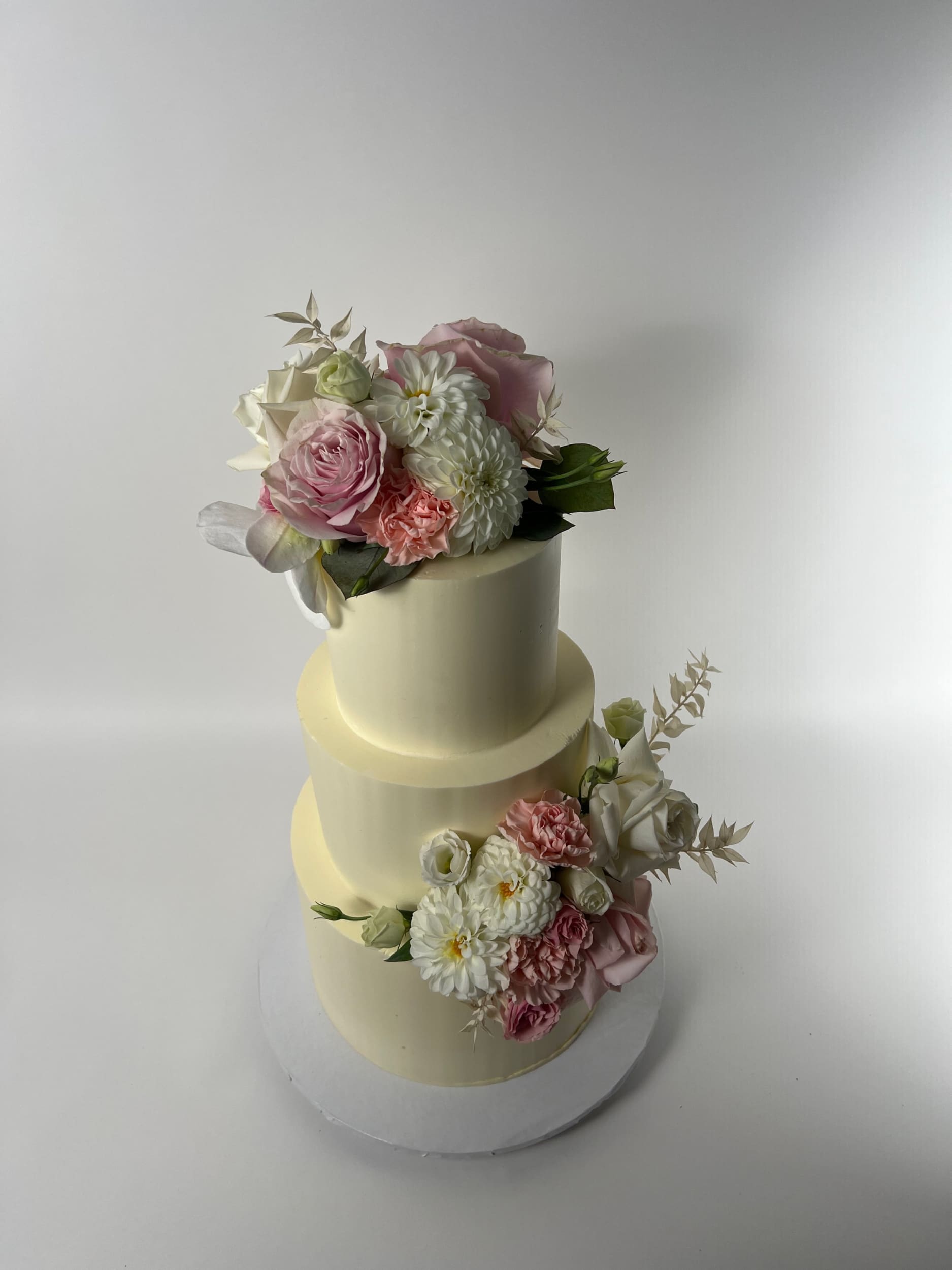 Fresh flowers on smooth buttercream - wedding cake