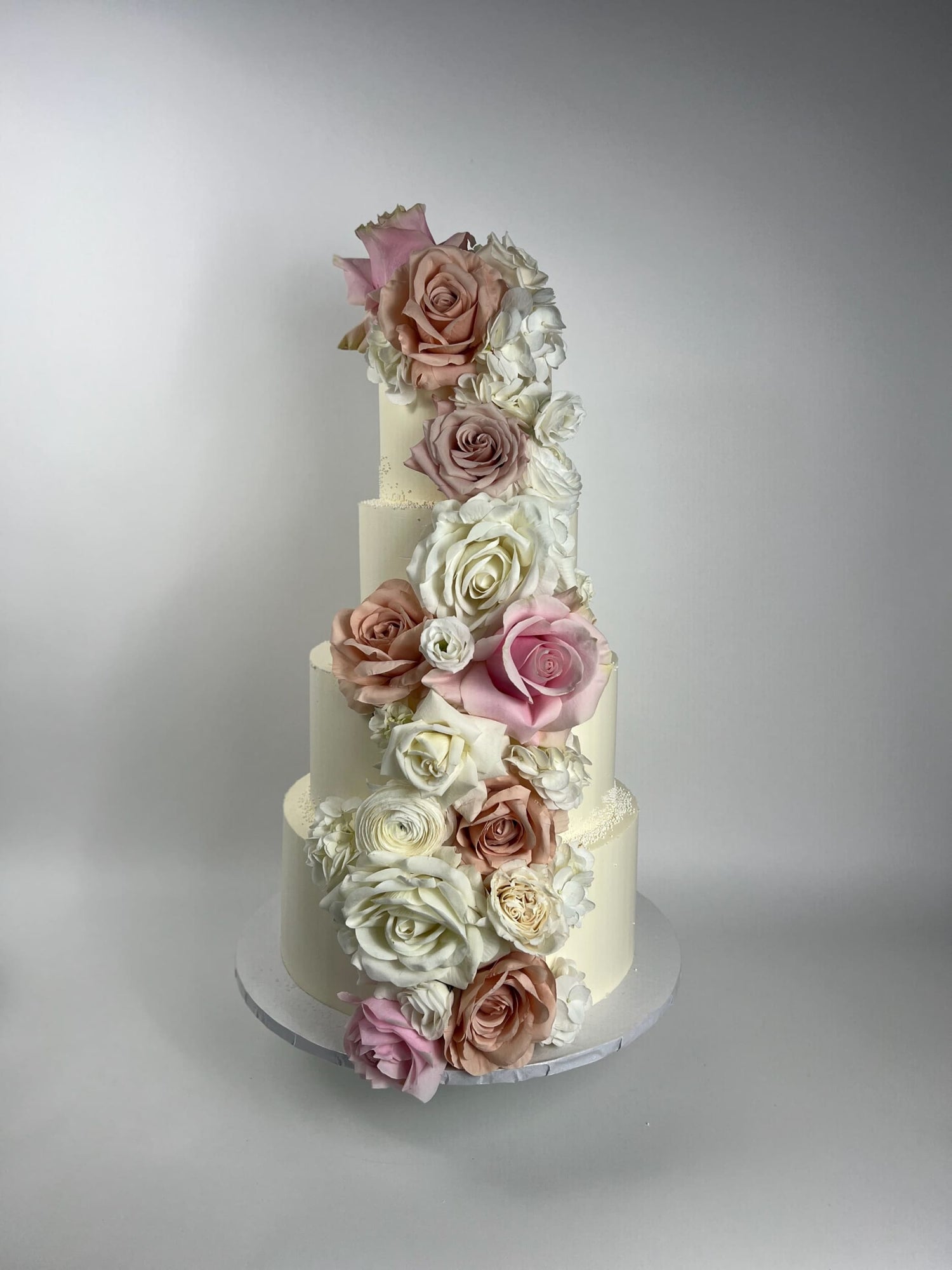 Cascading fresh flowers on buttercream - wedding cake