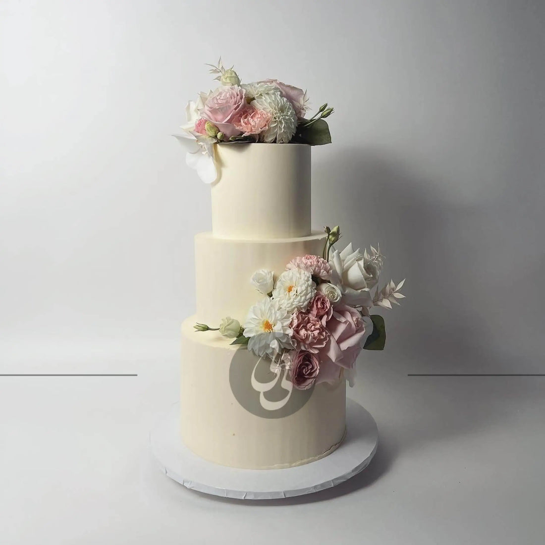 Fresh flowers on smooth buttercream - wedding cake