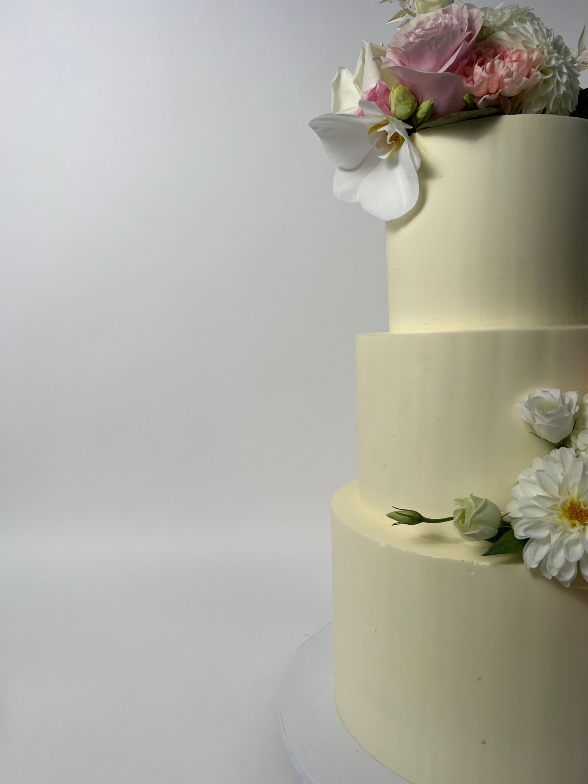 Fresh flowers on smooth buttercream - wedding cake