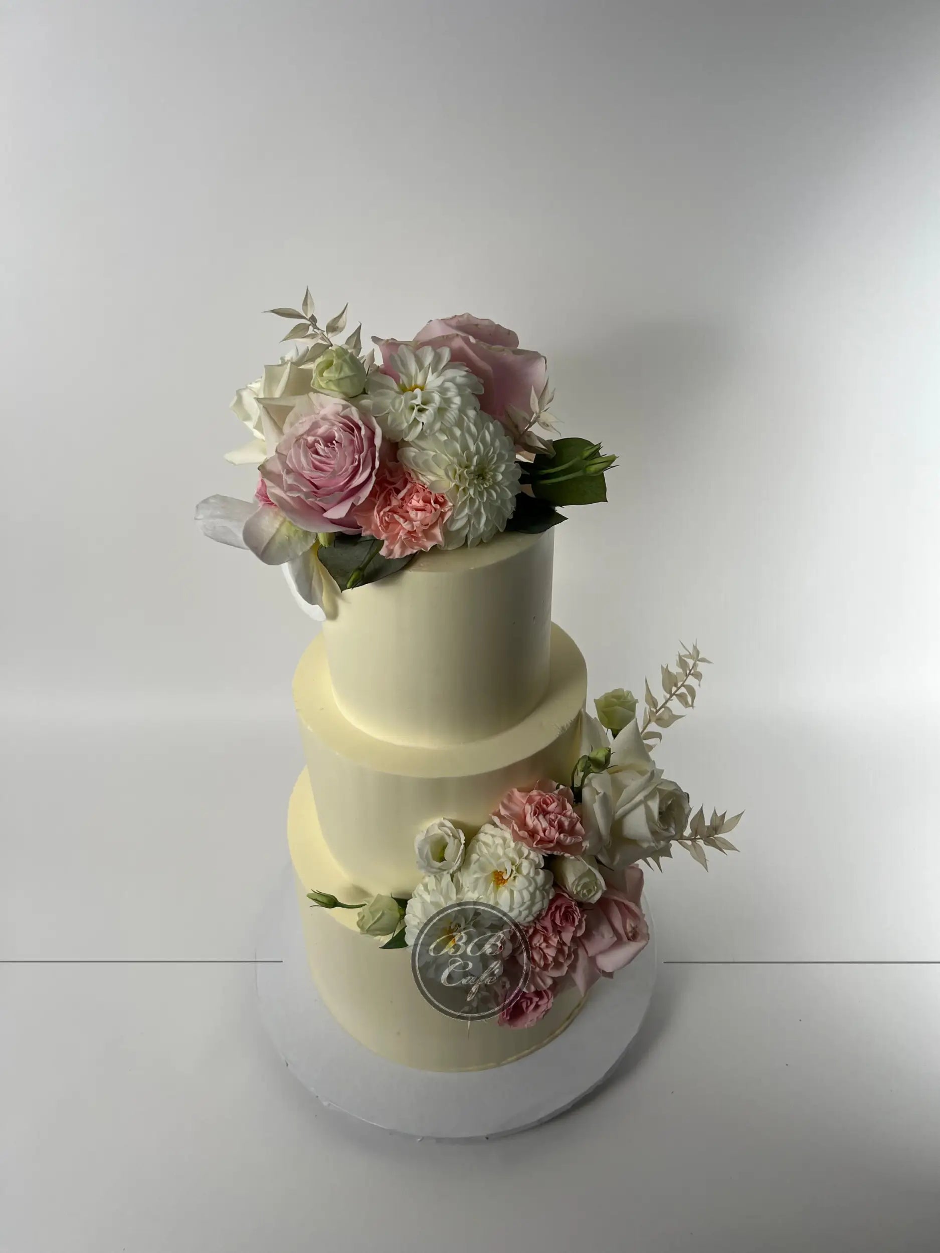 Fresh flowers on smooth buttercream - wedding cake