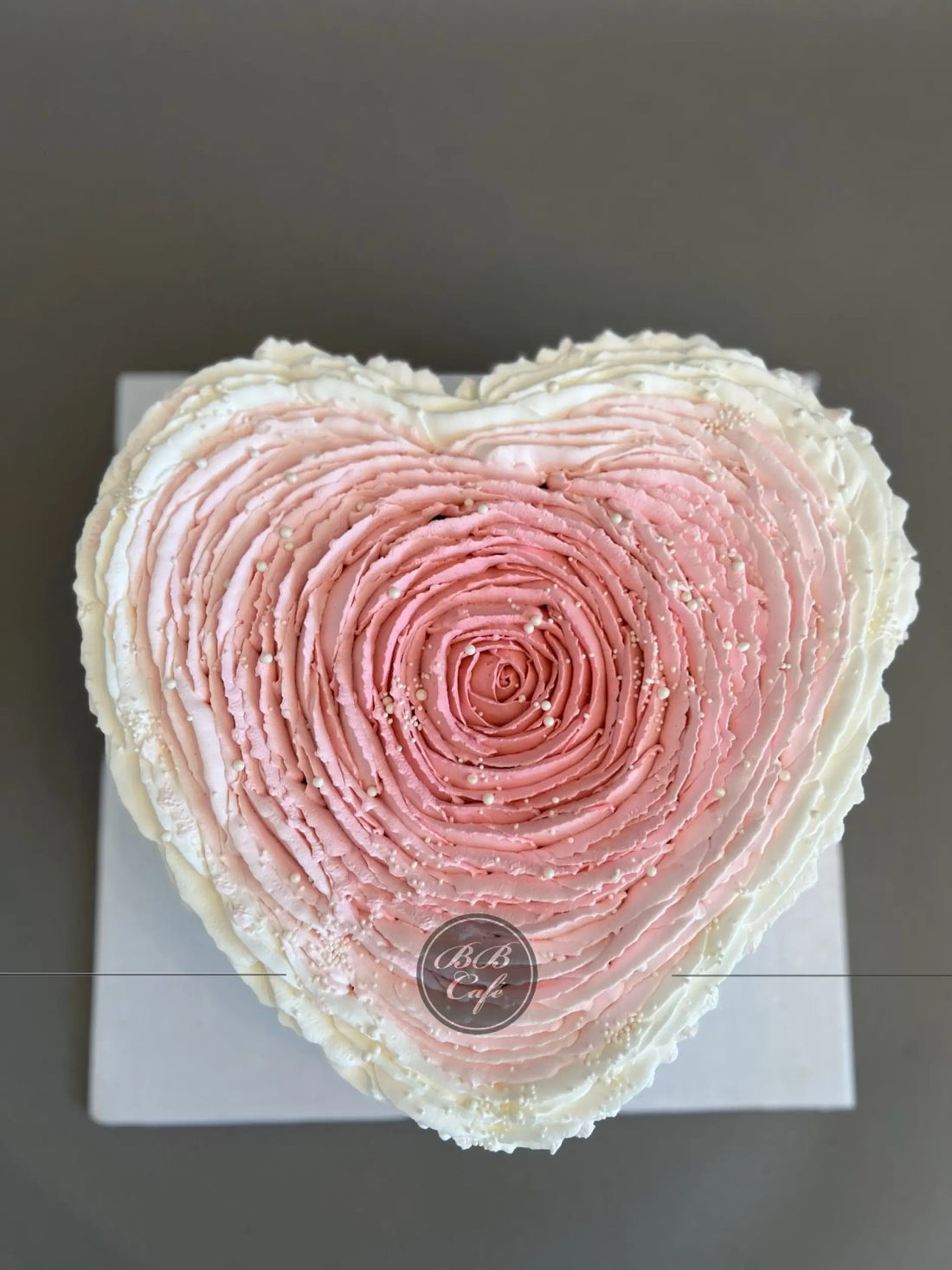 Hand piped ruffled rose on whipped cream heart - custom cake