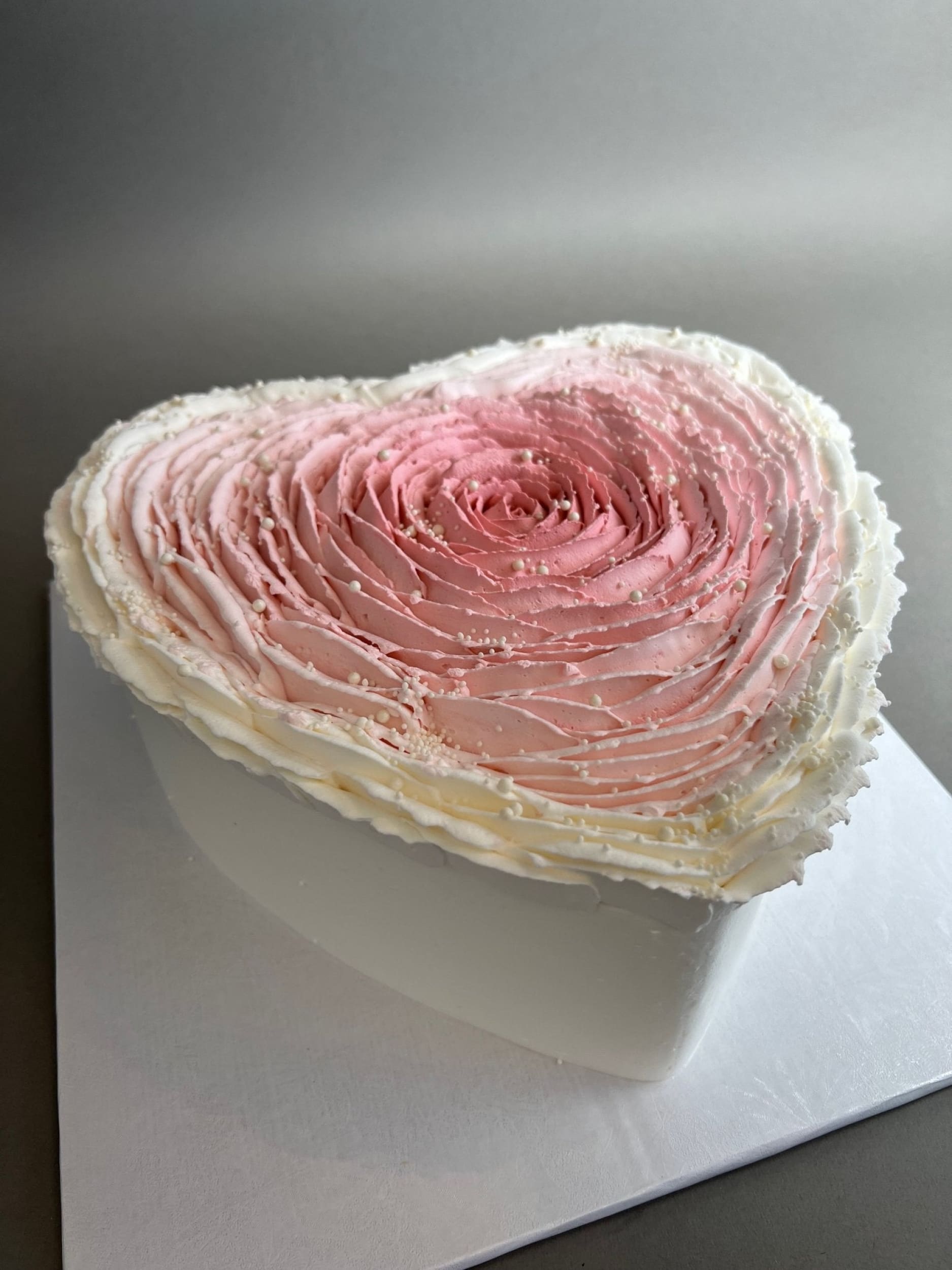 Hand piped ruffled rose on whipped cream heart - custom cake