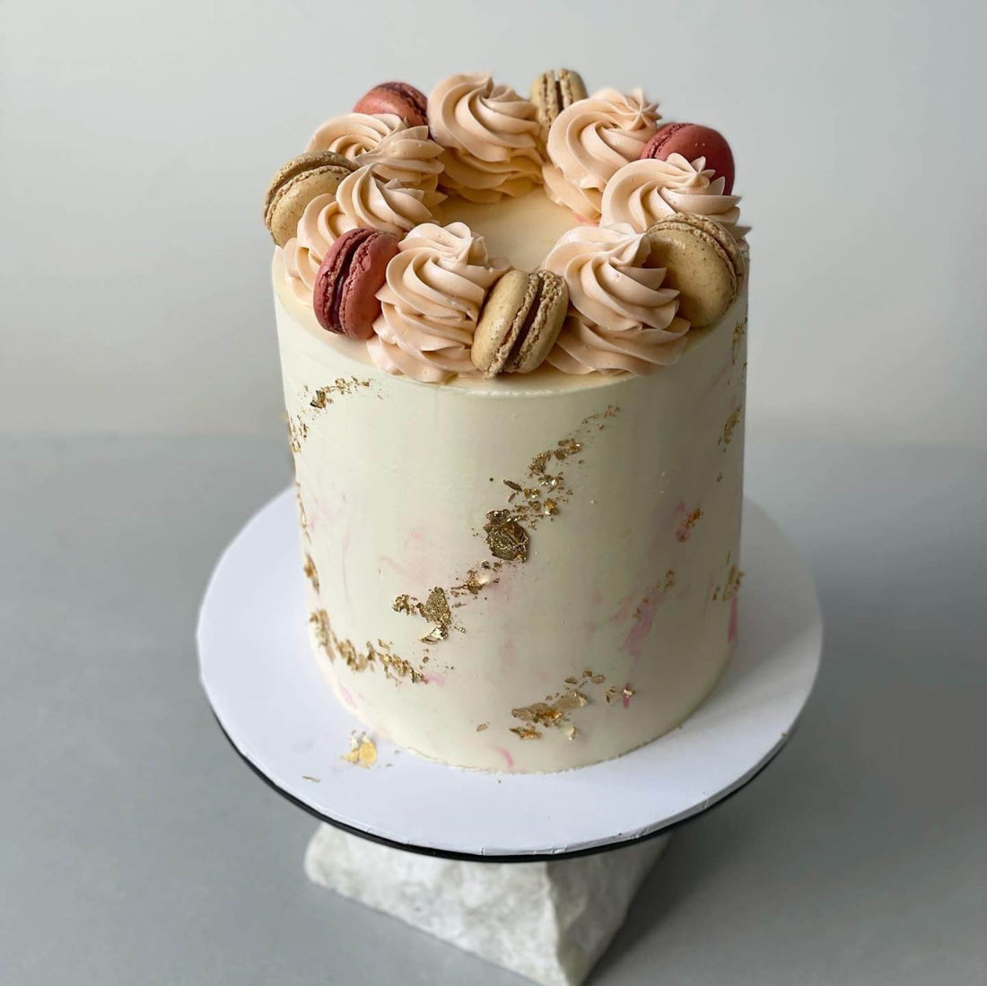 Macarons &amp; gold foil on marble buttercream - custom cake