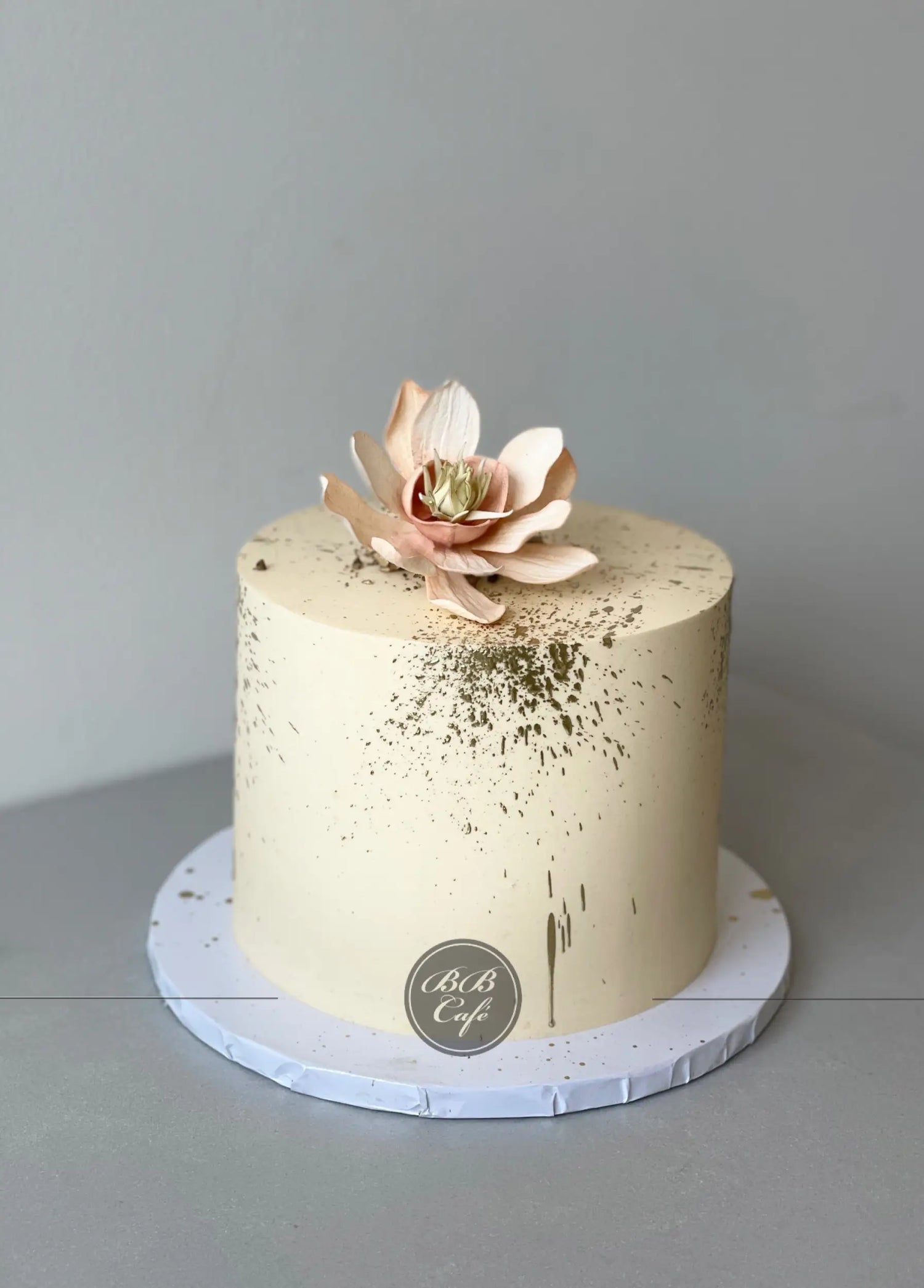 Sugar flowers &amp; gold splatter on buttercream - custom cake