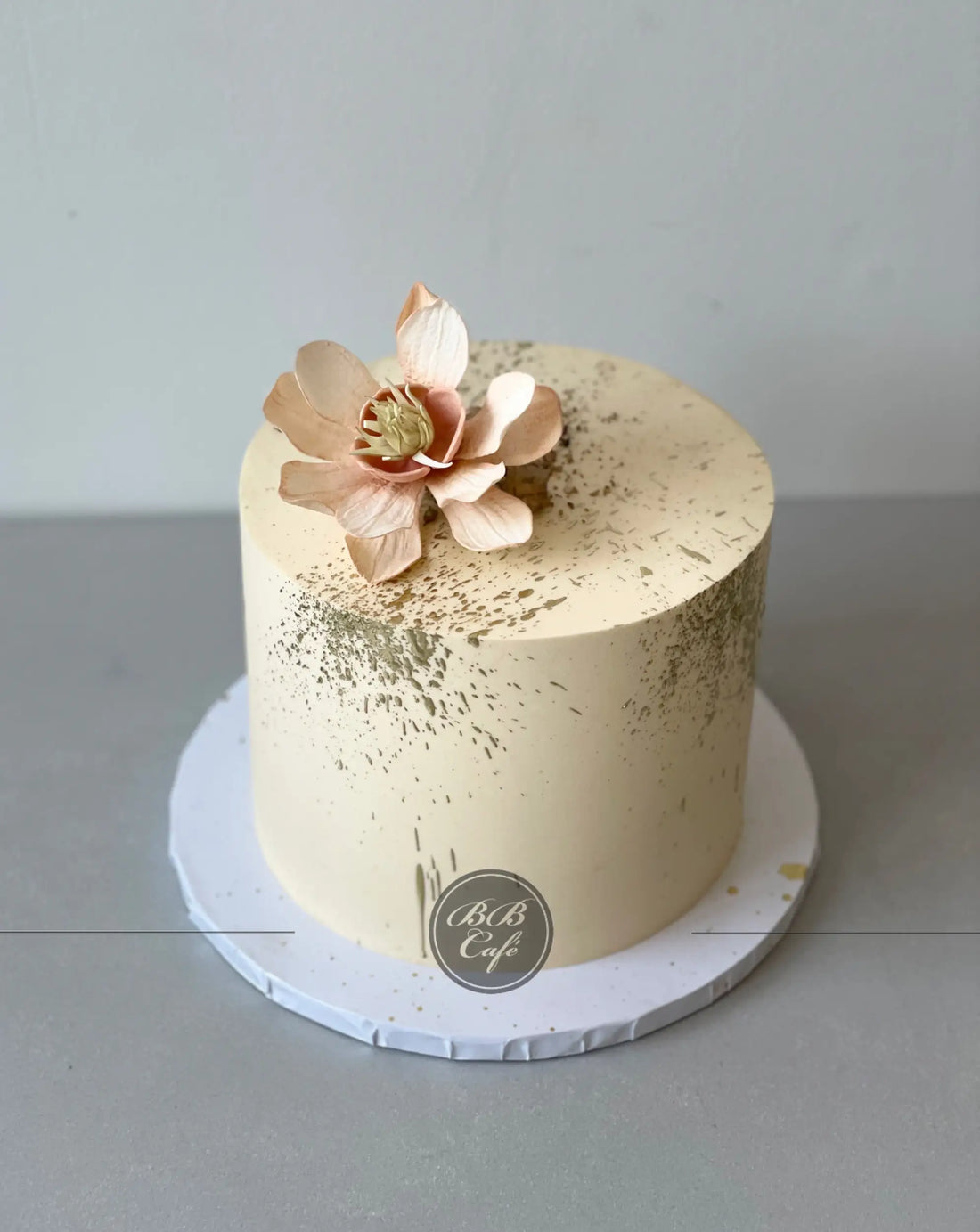 Sugar flowers &amp; gold splatter on buttercream - custom cake