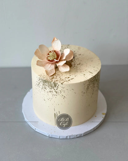 Sugar flowers &amp; gold splatter on buttercream - custom cake