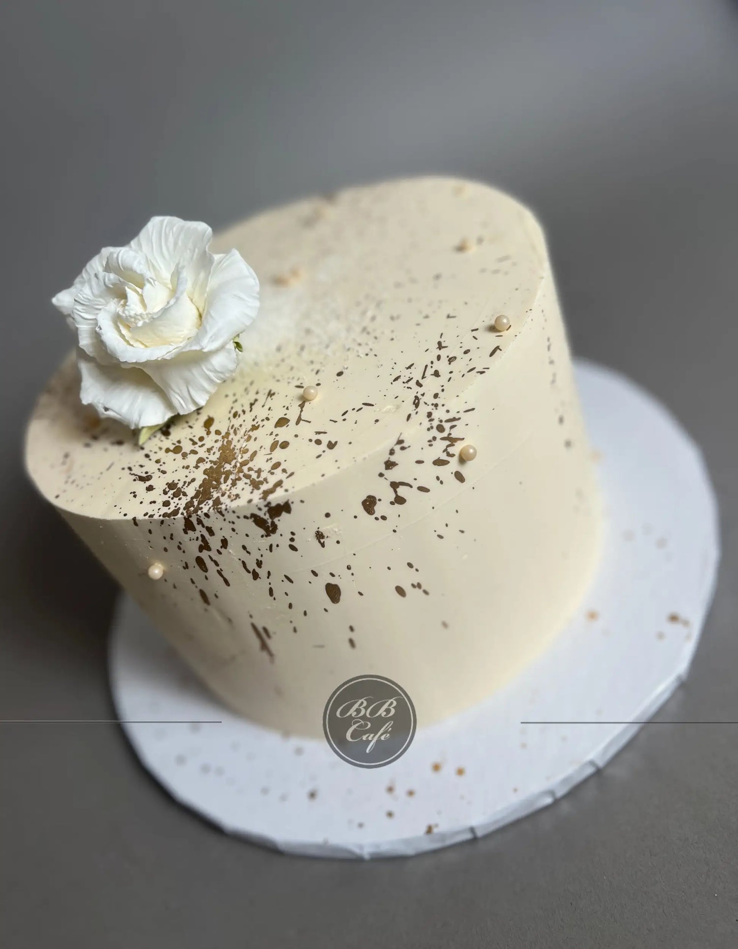 Sugar flowers &amp; gold splatter on buttercream - custom cake